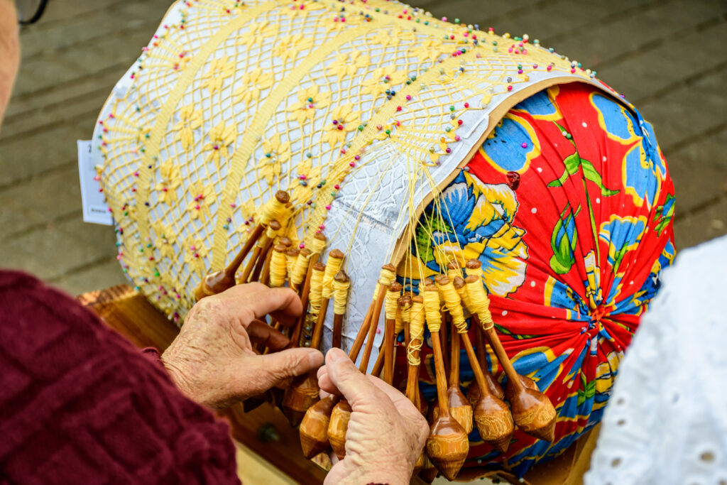 craftswoman making traditional bobbin lace handicrafts