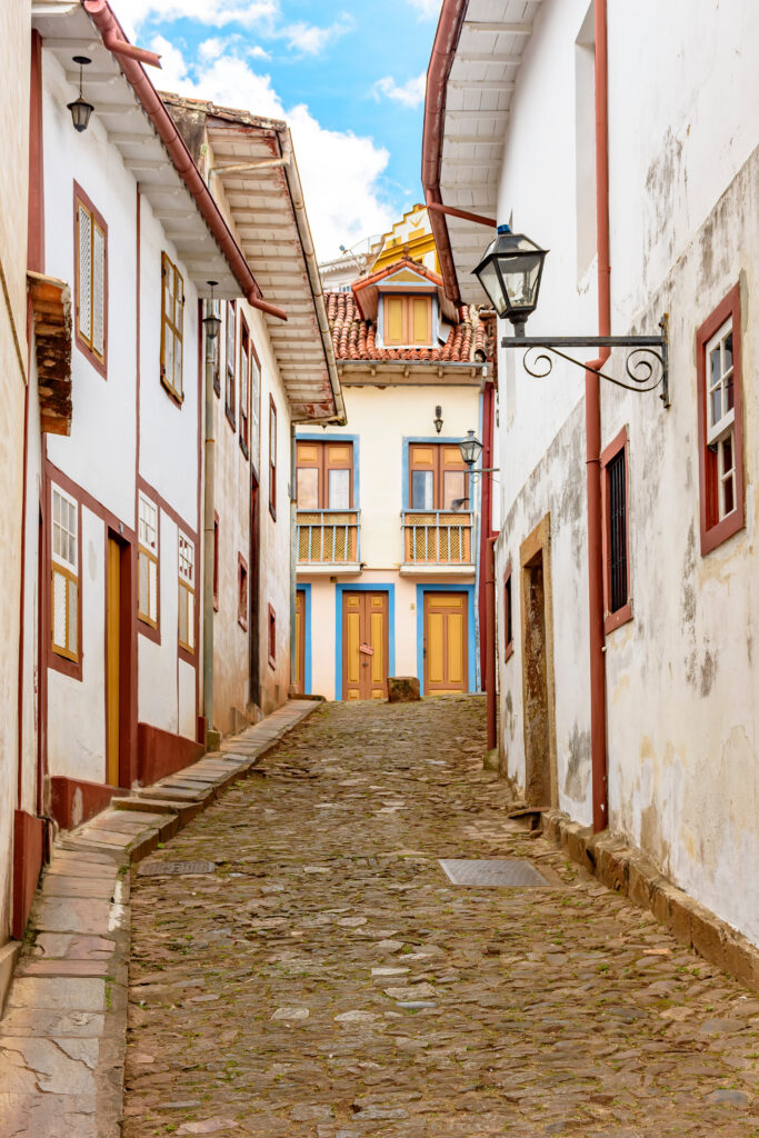Facade of old houses built in colonial architecture and cobblestone street